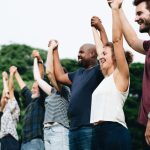Обьединение людей- A group of smiling people holding hands together, Kenwood Management Company investor family concept