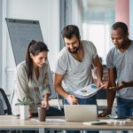 Зачем ставить финансовые цели - Business people standing over laptop at table in office
