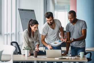 Зачем ставить финансовые цели - Business people standing over laptop at table in office