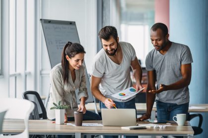 Зачем ставить финансовые цели - Business people standing over laptop at table in office