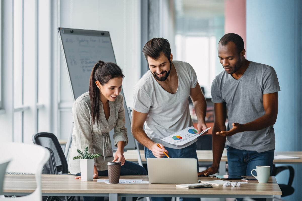 Зачем ставить финансовые цели - Business people standing over laptop at table in office